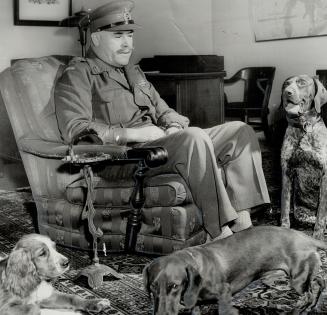 Headed by Maj.-Gen. Chris Vokes, seen relaxing with his three dogs, Joe a cocker spaniel, Gus, a dachshund, and Grock, German pointer, Central Militar(...)