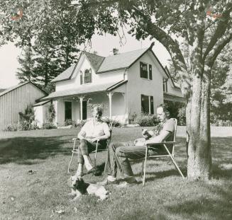 Alf and wife, Margaret, relax in the garden by their neat white house