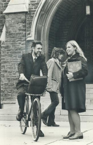 Dr. John Robson, principal of U of T's Victoria College, stops to chat with Linda Hall, a Victoria student. Robson cycles to college daily from his mi(...)