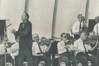 Summer Symphony Orchestra is conducted by George Crum while musicians succumb to Sunday's heat and play in shirtsleeves at CNE Bandshell. Parks department, musicians, Toronto Daily Star sponsor show