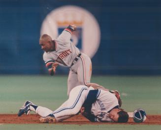 Ouch! Dick Schofield was knocked out of the game with an arm injury, while Milt Cuyler gets ready to dash for third last night at the SkyDome