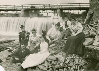Vintage photo people posing in front of small water fall in heavy clothing