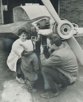 Bolting on the manifold of the plane he's building in the garage, Bill Brubacher gets a helping hand from his wife, Gail. Two-year-old Mary Ann just watches.