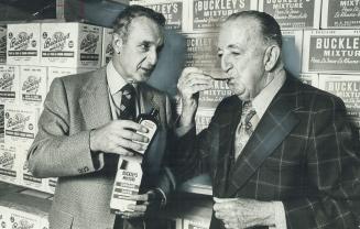First Batch of Buckley's Mixture was stirred up in a gallon jug in 1920 by William K. Buckley, 87, shown here sipping a spoonful of it offered by his son, Frank Buckley.