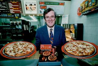 Changing course: McDonald's vice-president Peter Beresford shows off pizzas introduced in fast-food chain's menu last March.