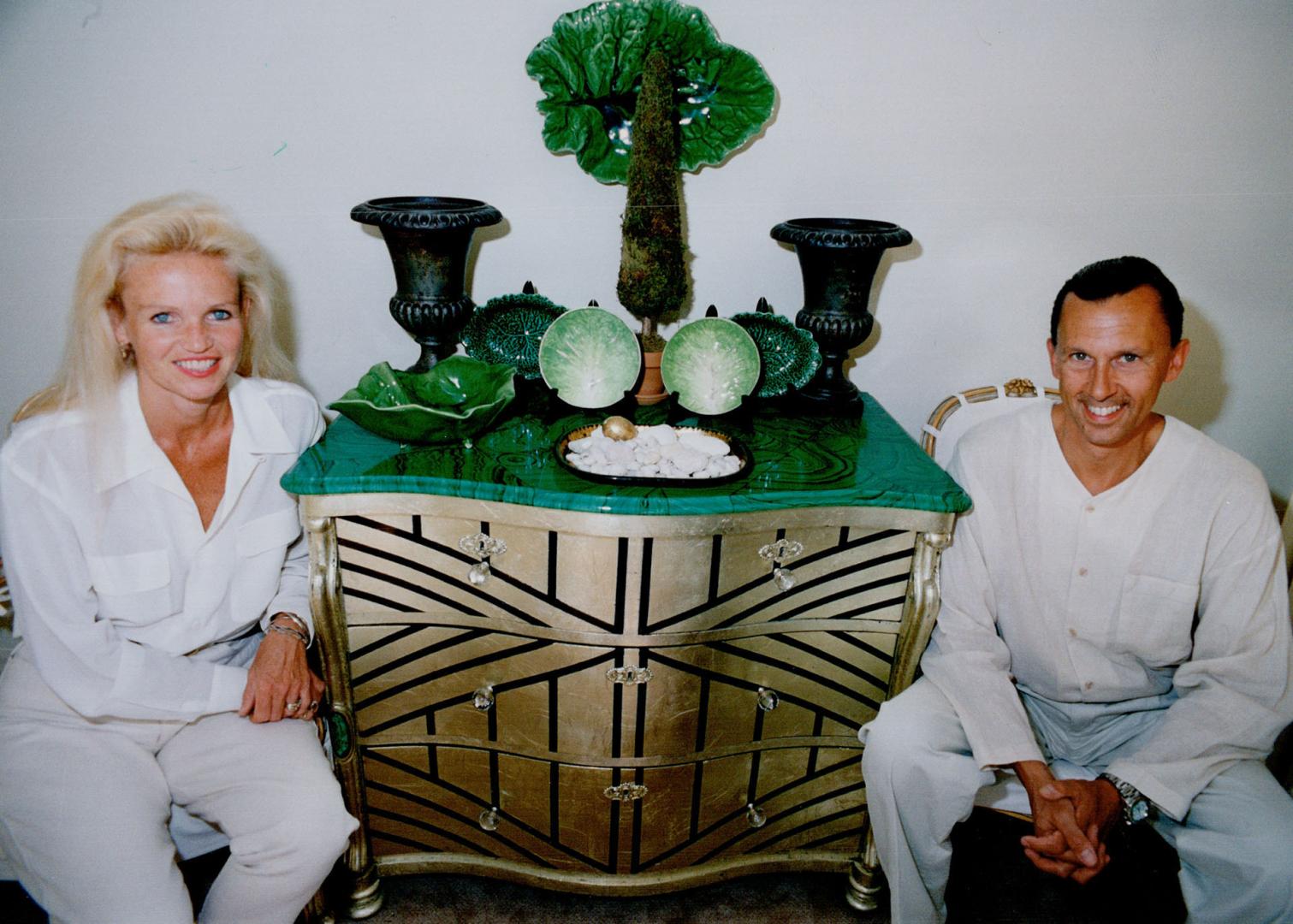 Michelle Lloyd-Bermann and David Bermann next to faux malachite-topped chest and lettuce china.