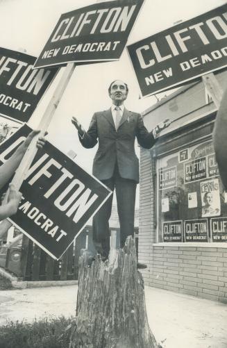 Stumping the hustings. Taking the politician's traditional chore of stumping the hustings quite literally, Roy Clifton, the New Democratic Party candidate in York Centre, stands on the stump of a dead elm in front of his campaign headquarters in Richmond Hill.