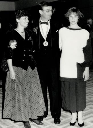 Patti Cunningham, in a Yvette velvet and silk dress, poses with husband Gordon, co-chairma of the raffle, and daughter Kristyn.