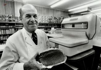 By the pound: James Duguid weighs meat and produce on imperial scales at the family's grocery store on Yonge St.