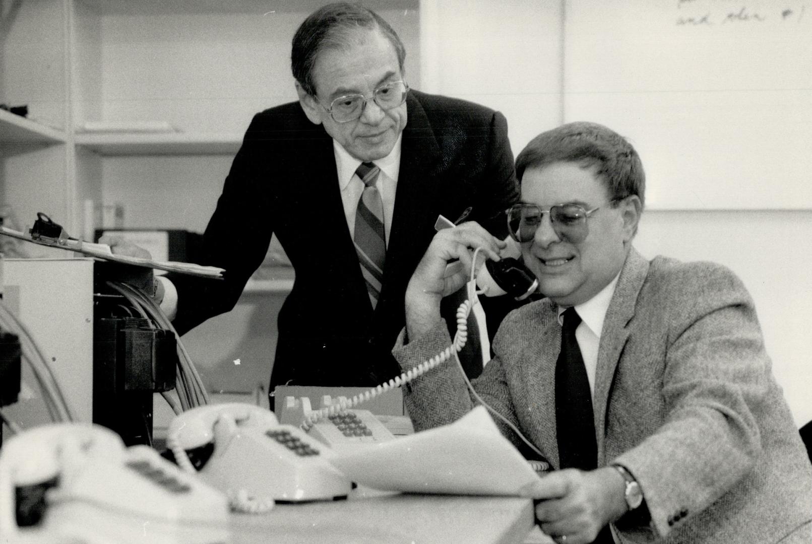 Hot lines: Carl Ellioff (seated) and Oscar Rechtshaffen of Teletalk Ltd. check the automated electronic equipment that handles an average 100,000 paid calls a month made to the firm.