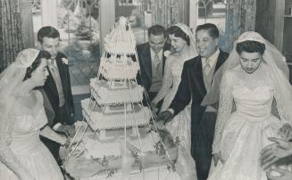 The happy couples are shown cutting their 225-pound weddding cake at the reception, which was held at the Peruvian embassy. The cake was elaborately decorated with drop icing loops and topped by three sets of tiny bridal figures. To see who would be marri