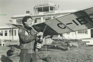 Flight's end: Pilot Rick Feamley squirts a bottle of bubbly to celebrate the end of his flight at Toronto Island Airport today.