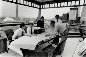 Balcony conference: Camrost president David Feldman, second right, meets staffers Brian Kevins, Barbara Paulin, Ted Davidson and Pat O'Hanlon on balcony of his downtown condo penthouse.