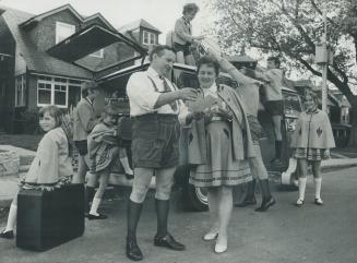 Mr. and Mrs. Ludwig Henkel check their list to see that everything - and everyone - is aboard their minibus before setting off for another engagement. The seven Henkel children, Rosalind, Barbara, Arnold, Doris, Walter, George Peter, all play musical instruments and are known as the Flatland Yodellers. They have been awarded the Metropolitan Toronto Good Citizen Medal for May.