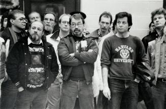 Grim situation: Tom Hoar, centre with beard and glasses, stands with supporters during last night's union local meeting