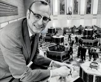 New chairman of the Toronto Stock Exchange is 42-year-old Donald G. Lawson, shown here looking over the exchanges's trading floor, Lawson, president of the brokerage firm of Moss, Lawson, president of the brokerage firm of Moss, Lawson and Co., succeeds W.H.A. Thorburn, Appointed governor was Dr. O.M. Solandt, retiring chancellor, University of Toronto.