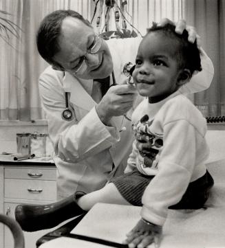 Special touch: Dr. Norman Lofchy gives 19-month-old Lacey Duke a checkup at the Albany Medical Clinic. Dr. Joe Strashin (far left) was a founder of the group medical practice clinic.