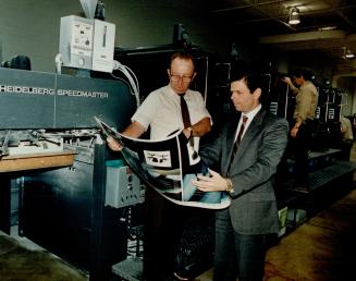 Arthurs-Jones manager Bob Carter (left) and president Duncan McGregor check color quality of a press run.