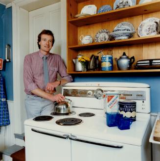 John McIntyre, curator of Ontario at Home, a new exhibition at the ROM, boils water for tea on his vintage electric range circa 1950.