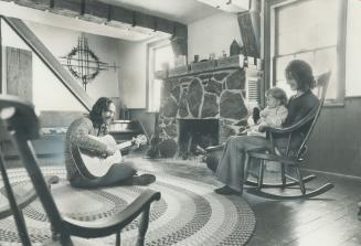 Derek Maw, an antique furniture craftsman, serenades wife Linda and daughter Justine, 2, in their Brooklin area pioneer farmhouse