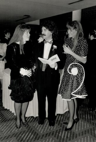 Freelance writer Judy Nyman, left, looks over the program with her husband, chartered accountant Harley Mintz, chairman of the board of the Reena Foundation, as Lisa Raphael looks on