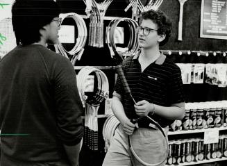 Active life: Jay Oelbaum shows a customer a new tennis racquet at the sporting goods store where he works