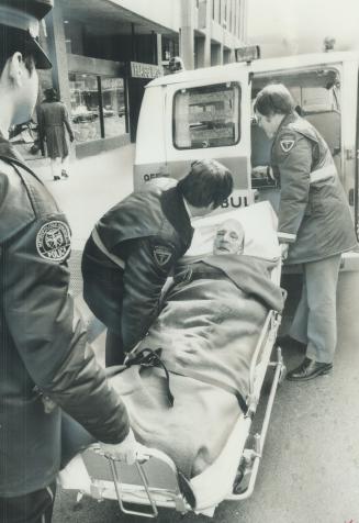Robbery Victim Frederick Ransford, 79, is lifted aboard ambulance today after being tied up and gagged in apartment in a senior citizen' building on Yonge St