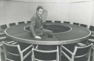British-born architect Leslie Rebanks perches on round-table in the board room of the building in Toronto