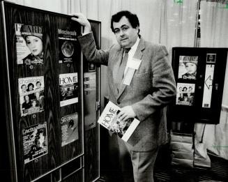 Mechanized magazine rack: Paul Runstedler, chairman of the 31st annual convention of the Canadian Automatic Merchandising Association, takes magazine out of vending machine during the weekend exhibition at the Constellation Hotel