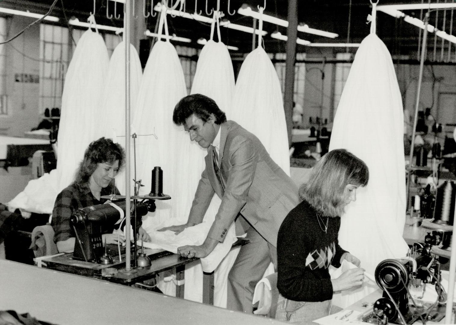 Plunging into work: John Simis likes to look in on the parachute making the Erika Nepp (left) and Diane Schmidt have in hand at Irvin industries Fort Erie plant