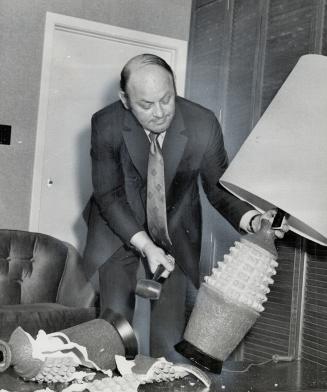 Shatter-proof lamp base developed by Toronto's Electrolite Products is demonstrated by Henry Shapiro, president of the firm