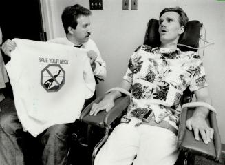 It's your neck: Quadriplegic Gary Stockfish (left) shows Steve McPherson one of the T-shirts in the Save Your Neck campaign aimed at vacationers