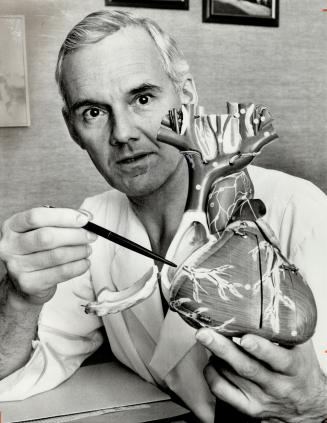 Surgeon Dr. George Trusler with model of a heart