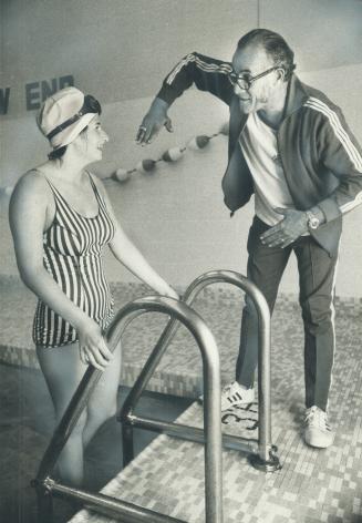 Training to swim both Lake Ontario and the English Channel this year, Angela Kondrak, 15, confers with her coach, Art Dufresne, at Harrison Baths, near Queen and McCaul Sts
