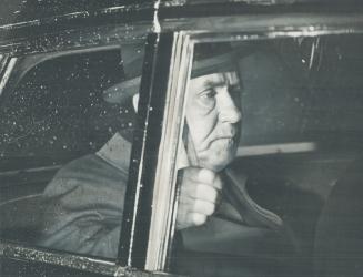 Hanging on tight to the hand-strap in the rear seat of his limousine, visiting Soviet Premier Alexei Kosygin rides through the rain last night from Toronto International Airport to the Inn on the Park, where he spent the night