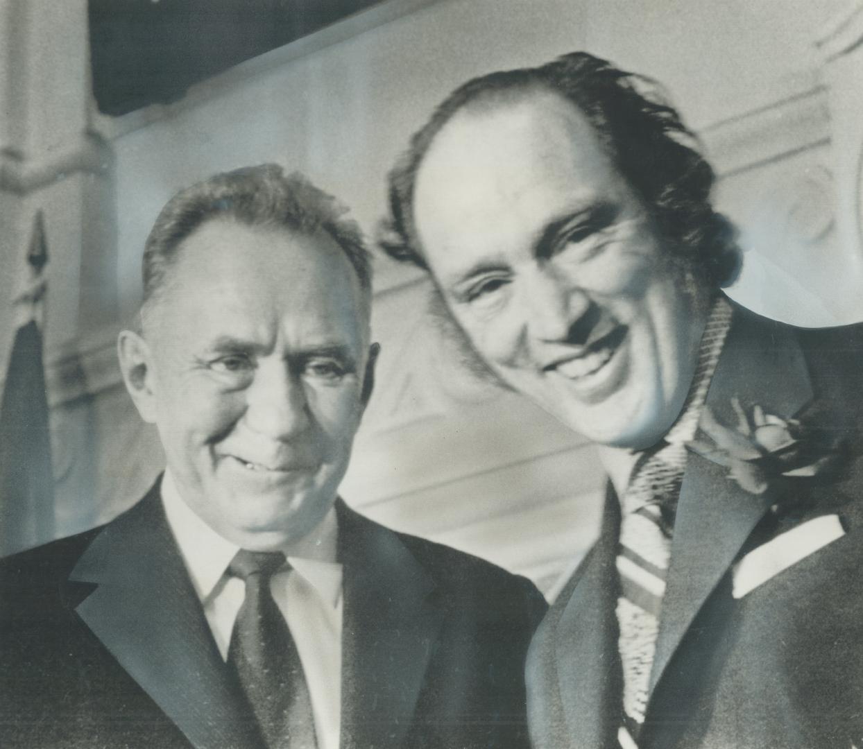 Wearing a smile-and-a-half, a full one on the face of Prime Minister Pierre Trudeau, a half smile on the face of Soviet Premier Alexei Kosygin, the two leaders stand together today in the Parliament Buildings after signing agreement on exchange visits between the two nations, then toasting the pact with champagne