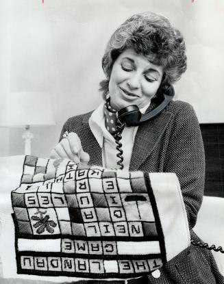 Edythe Landau, Film executive. She's working on a crossword puzzle cushion