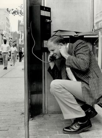 Contortionist: Columnist Lautens risks injury as he struggles to converse in indoor phone booth at Eaton Centre.