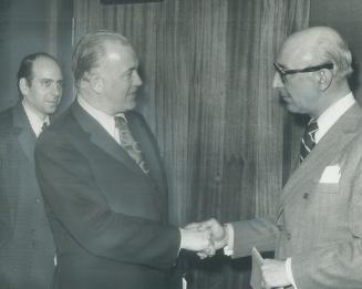 At end of inquiry by the provincial governement into hospital privileges in Ontario, Health Minister Bert Lawrence shakes hands with two doctors whose complaints prompted him to set up commission. Dr. Claude Macdonald (centre), Dr. J. E. Sheriton (left). Both doctors say they are happy with results of inquiry.