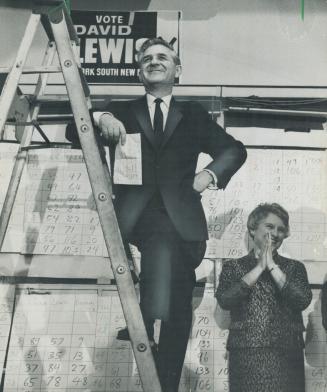 David Lewis mounts ladder so admirers can see him. Mrs. Lewis claps hands at his win for the NDP in York South