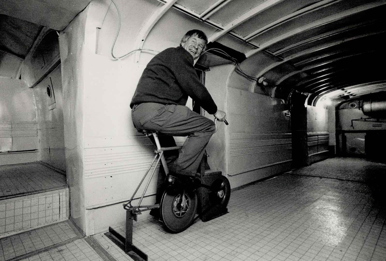 Cycle system: Star photographer Dick Loek tries a bicycle linked to a blower which can circulate air through the multi-room super-bunker