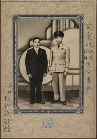 Studio portrait of Robert Shun Wong dressed in E.F.T.S. pilot uniform with another gentleman