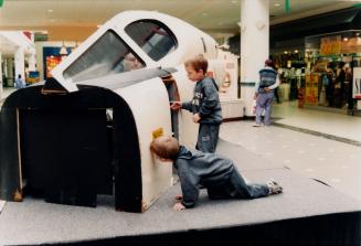 David and Dylan Bracken, 4, looking at the Avro Arrow cockpit simulator. Bramalea City Centre, Bramalea, Ontario