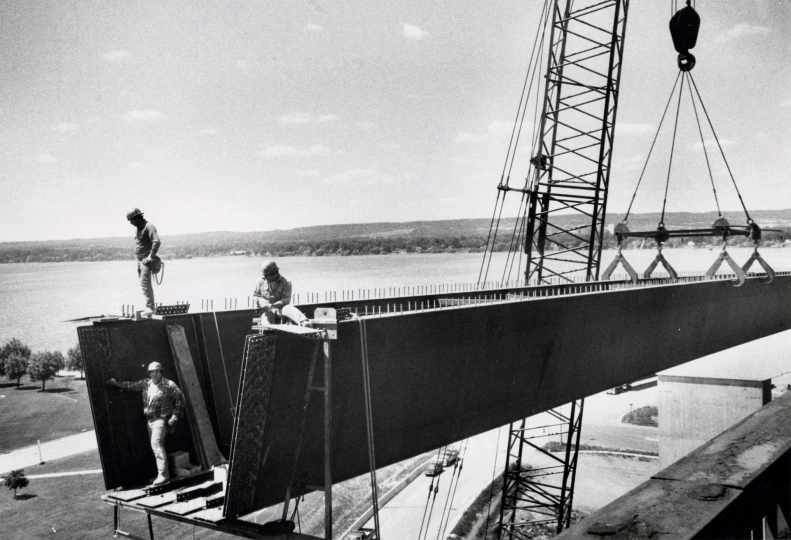 Steelworkers joining 100-tonne beams to the concrete supports of the new Burlington Skyway span. Burlington, Ontario