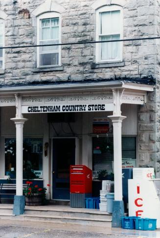 Entrance to a stone building with two steps, a blue door, and a mailbox.