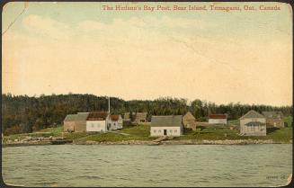 Buildings including a church on the shore of a lake in the wilderness. Colorized photograph,