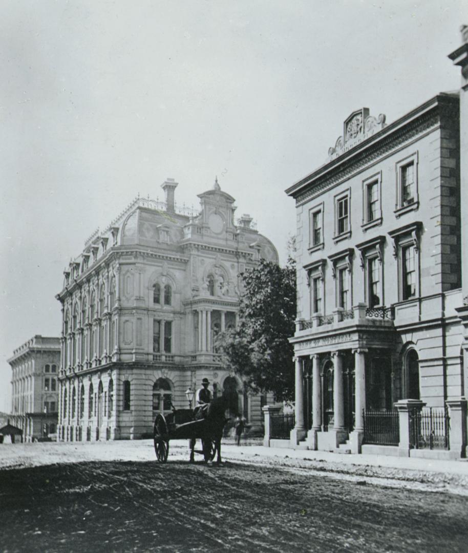 Image shows a few multi-floor buildings and a horse carriage in front of one of them.