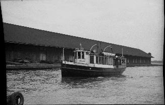 Image shows a ferry passing by the wharf.