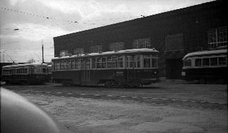 Image shows a few rail cars by the building.
