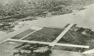 Image shows an aerial view of the island airport with the Harbour in the background.